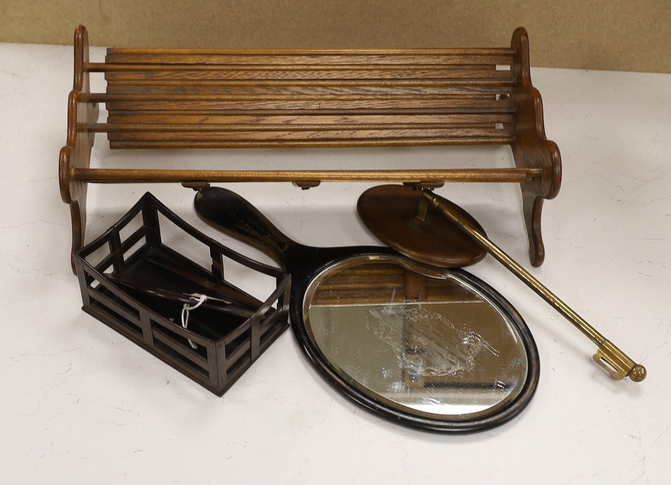 An oak book trough, a rosewood rack, a hand mirror and a telescopic hand mirror